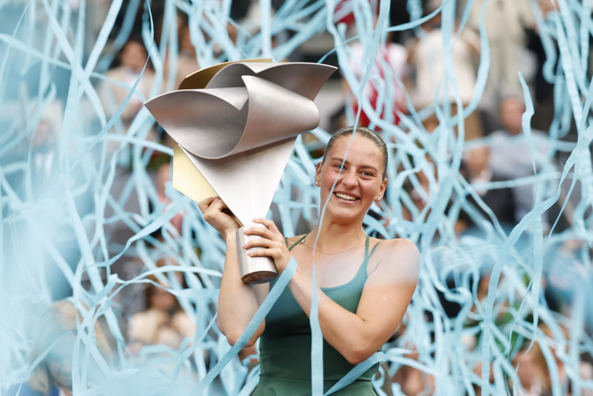 La tenista ucraniana Marta Kostiuk celebra con su trofeo la victoria ante la rusa Mirra Andréyeva, durante la final individual femenino del Abierto de Madrid de Tenis disputada este sábado en la Caja Mágica en Madrid.EFE/ Chema Moya