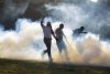 Personas huyen de gases lacrimógenos tras enfrentamientos con integrantes de la Policía Nacional dominicana este domingo, en San Juan de la Maguana (República Dominicana). EFE/ Orlando Barría
