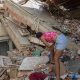 Una mujer busca entre los escombros de las edificaciones destruidas por los terremotos, este domingo, en Catia La Mar (Venezuela). EFE/ Henry Chirinos