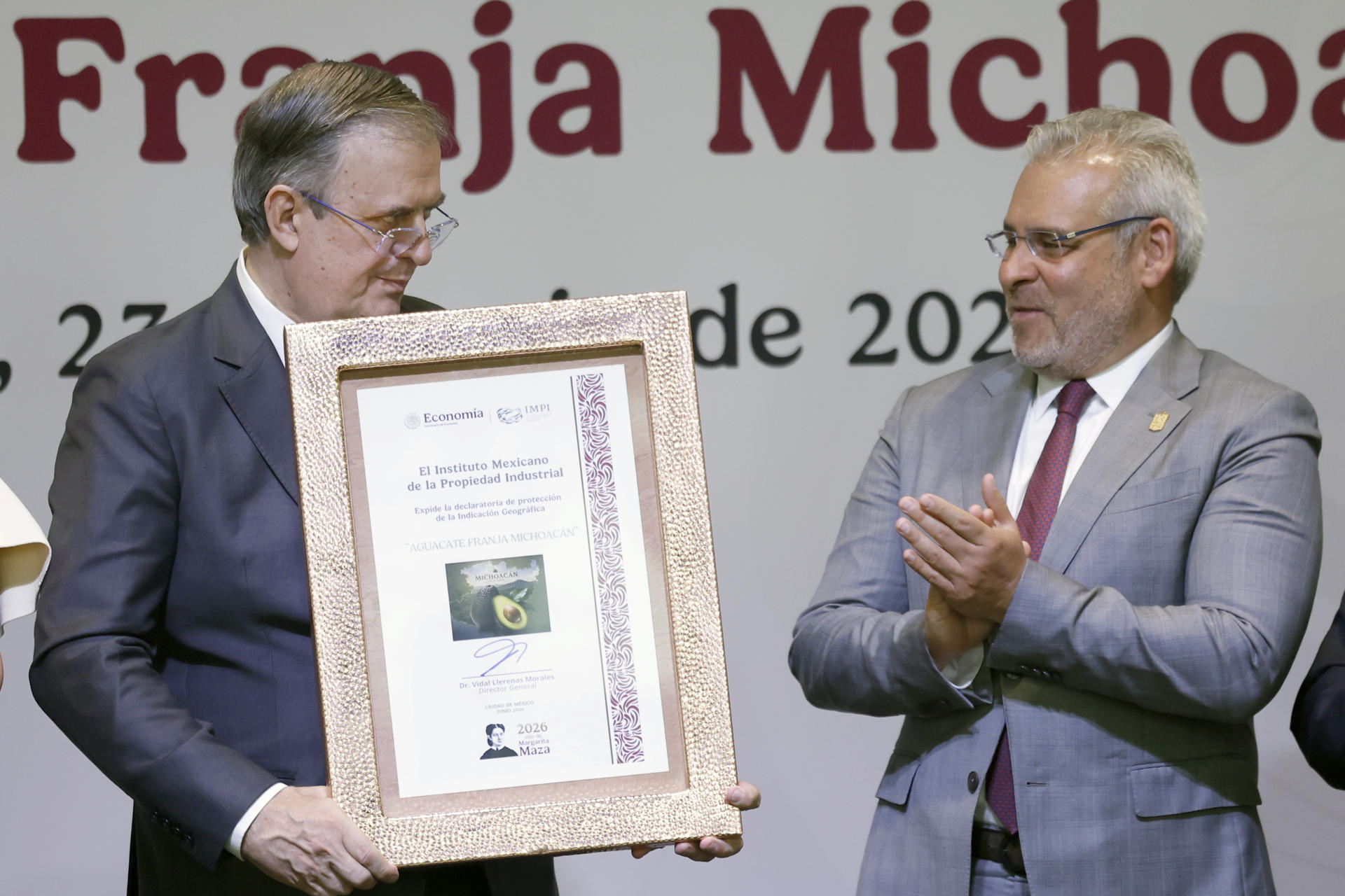 El secretario de Economía de México, Marcelo Ebrard (i), sostiene el reconocimiento de indicación geográfica al aguacate Franja Michoacán junto al gobernador de Michoacán, Alfredo Ramírez, en una rueda de prensa este martes, en Ciudad de México (México). EFE/Sáshenka Gutiérrez