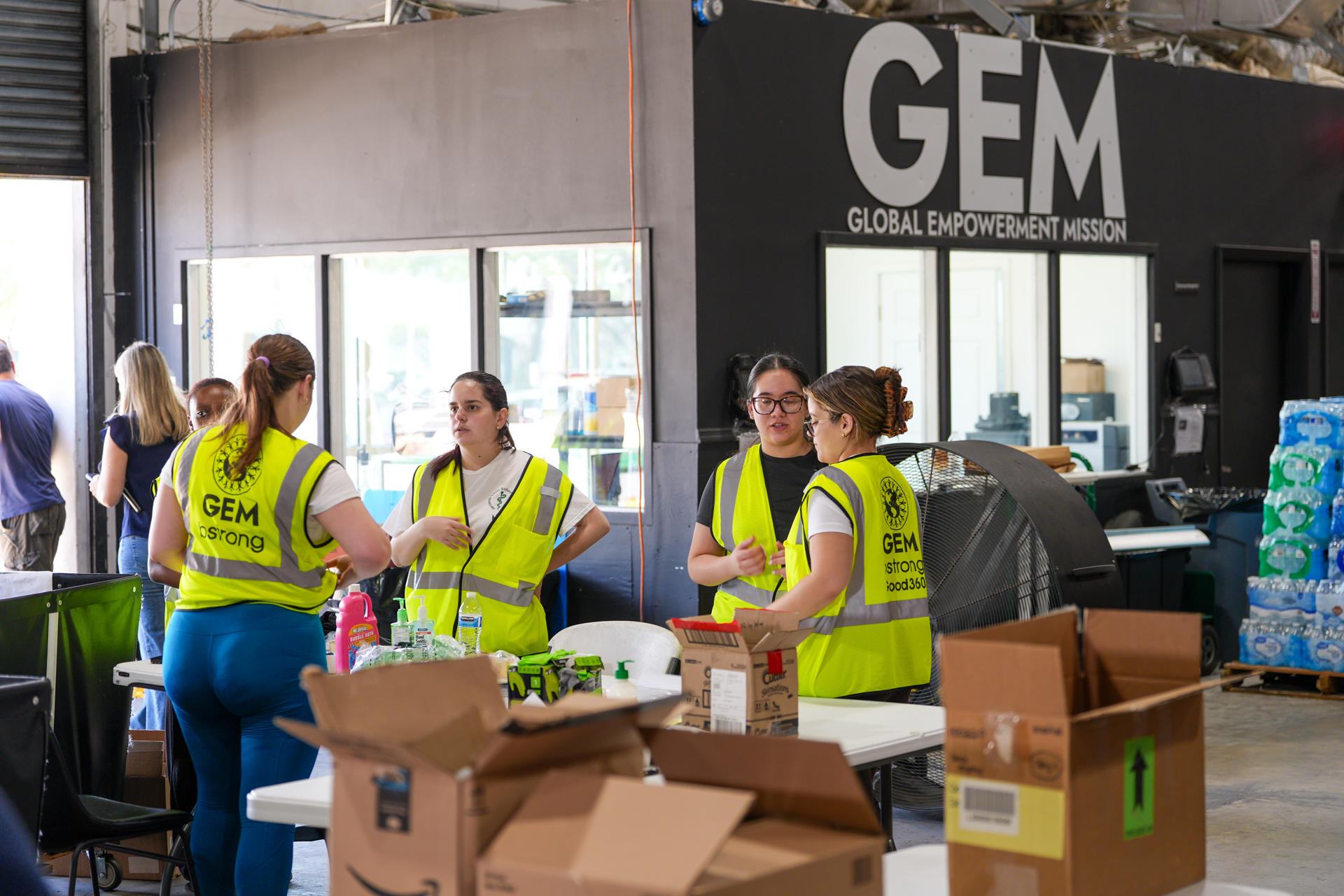 Voluntarias de Global Empowerment Mission (GEM) empacan cajas con alimentos este jueves, en la sede de la organización en Doral, Miami (Estados Unidos). EFE/ Alberto Boal