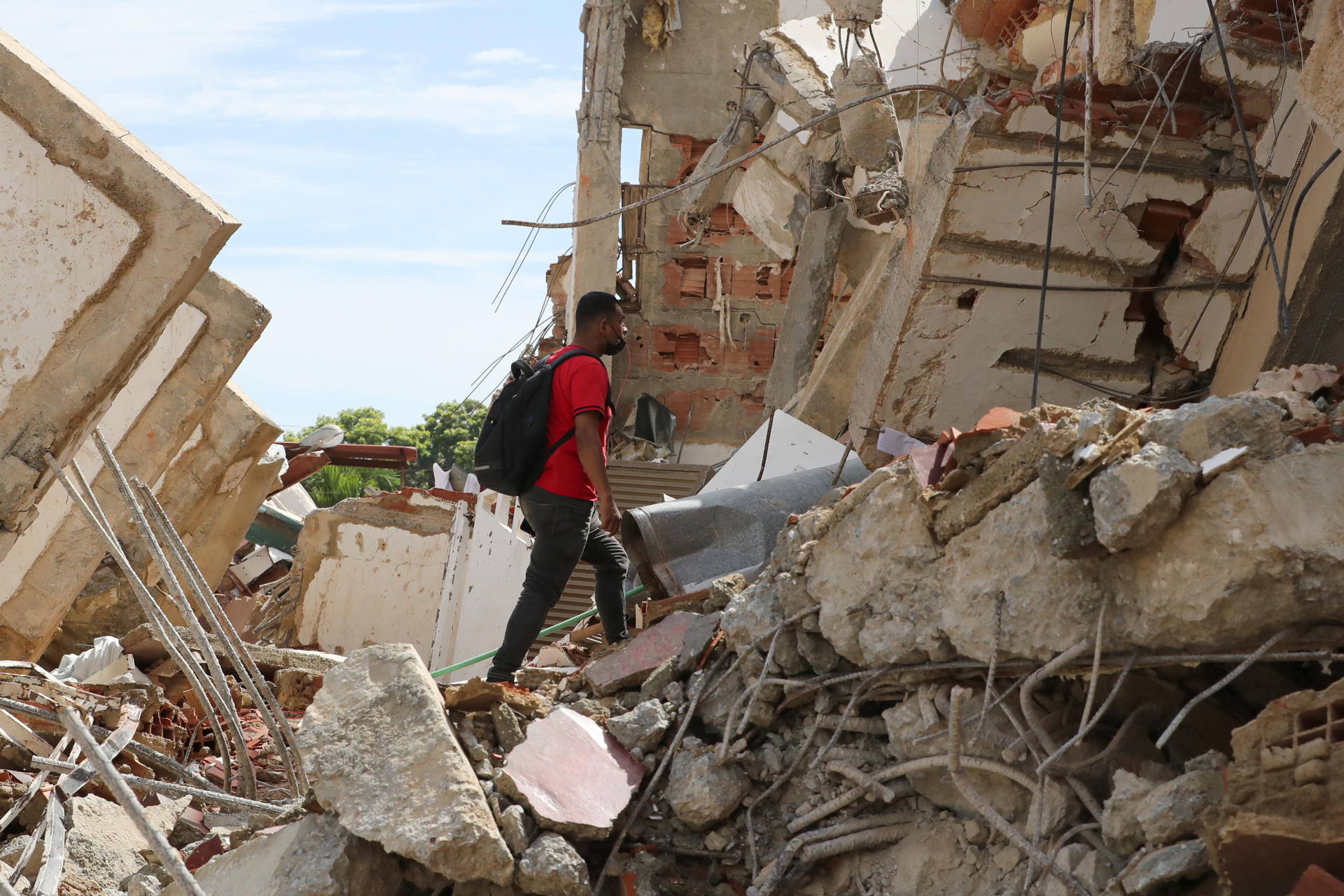 Un hombre camina sobre escombros de edificaciones destruidas este martes, en La Guaira (Venezuela). EFE/ Raúl Martínez