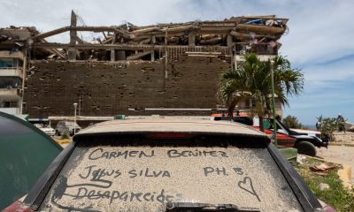 Detalle del vidrio panorámico de un automóvil cubierto de polvo y con los nombres de personas desaparecidas durante los terremotos del pasado miércoles, en Catia La Mar (Venezuela). EFE/ Ronald Peña
