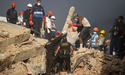 Voluntarios y funcionarios de Cuerpo de Investigaciones Científicas, Penales y Criminalísticas (Cicpc), trasladan un cuerpo este lunes, en La Guaira (Venezuela). EFE/ Ronald Peña R