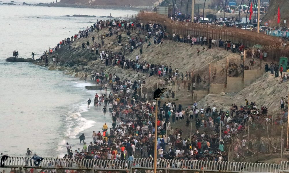 Multitud de personas se concentran en la parte marroquí de la playa del Tarajal para intentar acceder a Ceuta. EFE / Reduan.