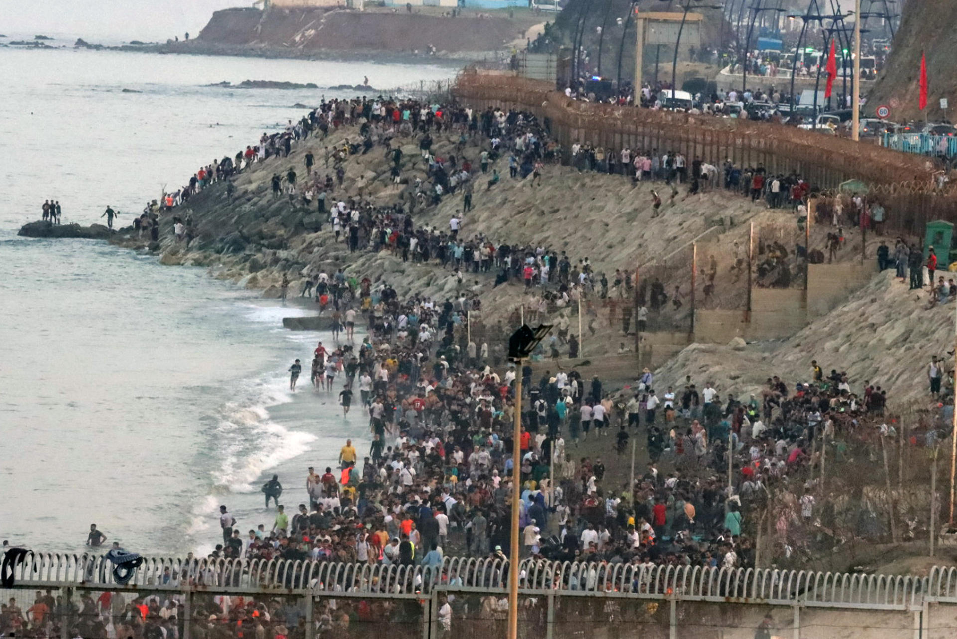 Multitud de personas se concentran en la parte marroquí de la playa del Tarajal para intentar acceder a Ceuta. EFE / Reduan.