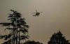 Un helicóptero de extinción de incendios vuela entre el humo de un incendio forestal que se propaga en Cap Ferret, en Lège-Cap-Ferret, en el suroeste de Francia. EFE/EPA/JULIEN REGUL