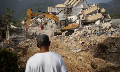 Una persona observa maquinaria pesada removiendo escombros en La Guaira (Venezuela). EFE/ Ronald Peña R