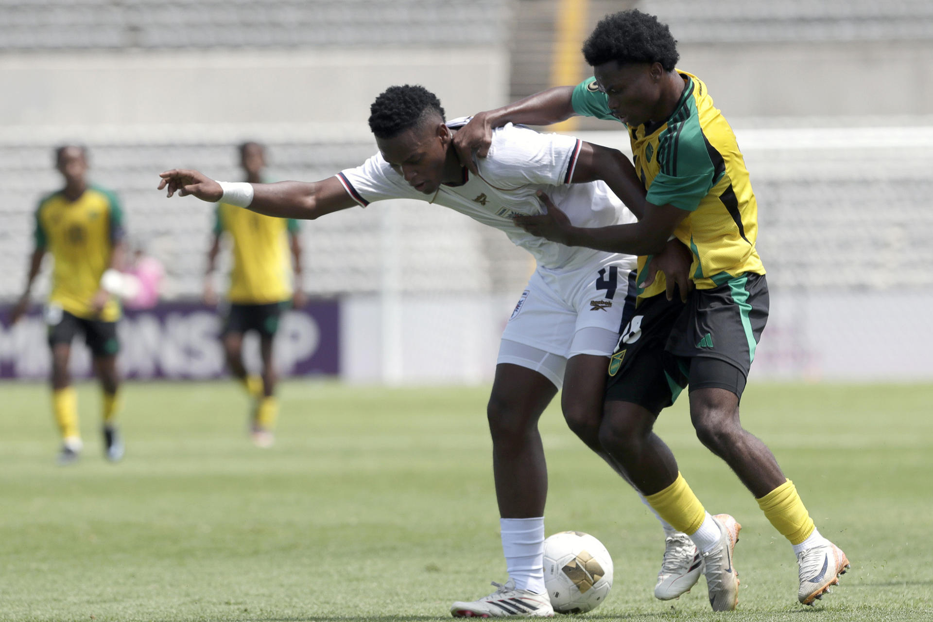 Kimarly Scott (d) de Jamaica disputa el balón con Josué Wood de Panamá este miércoles, durante un partido del Campeonato Sub-20 de la Concacaf entre Jamaica y Panamá, en el estadio Universitario en Puebla (México). EFE/ Hilda Ríos