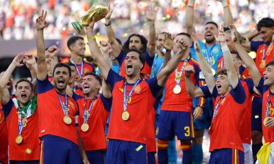 El español Mikel Merino levanta el trofeo de la Copa del Mundo mientras el equipo celebra tras ganar la final de la Copa Mundial de la FIFA 2026. EFE/EPA/CHRISTOPHER NEUNDORF
