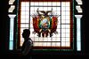 Una persona camina frente a un vitral con el escudo de Bolivia este jueves, en el Museo Nacional de Arqueología, en La Paz (Bolivia). EFE/ Luis Gandarillas

