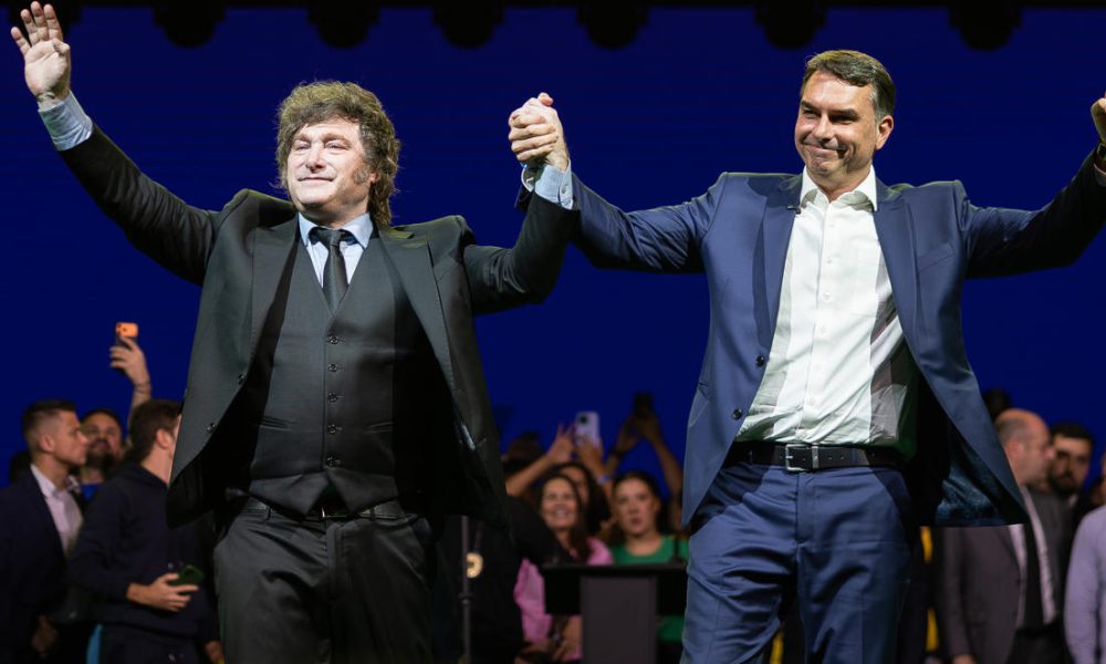 El senador de Brasil Flávio Bolsonaro (d) y el presidente de Argentina, Javier Milei (i), reaccionan en la convención nacional del Partido Liberal de Brasil (PL) este sábado, en São Paulo (Brasil). EFE/ Isaac Fontana