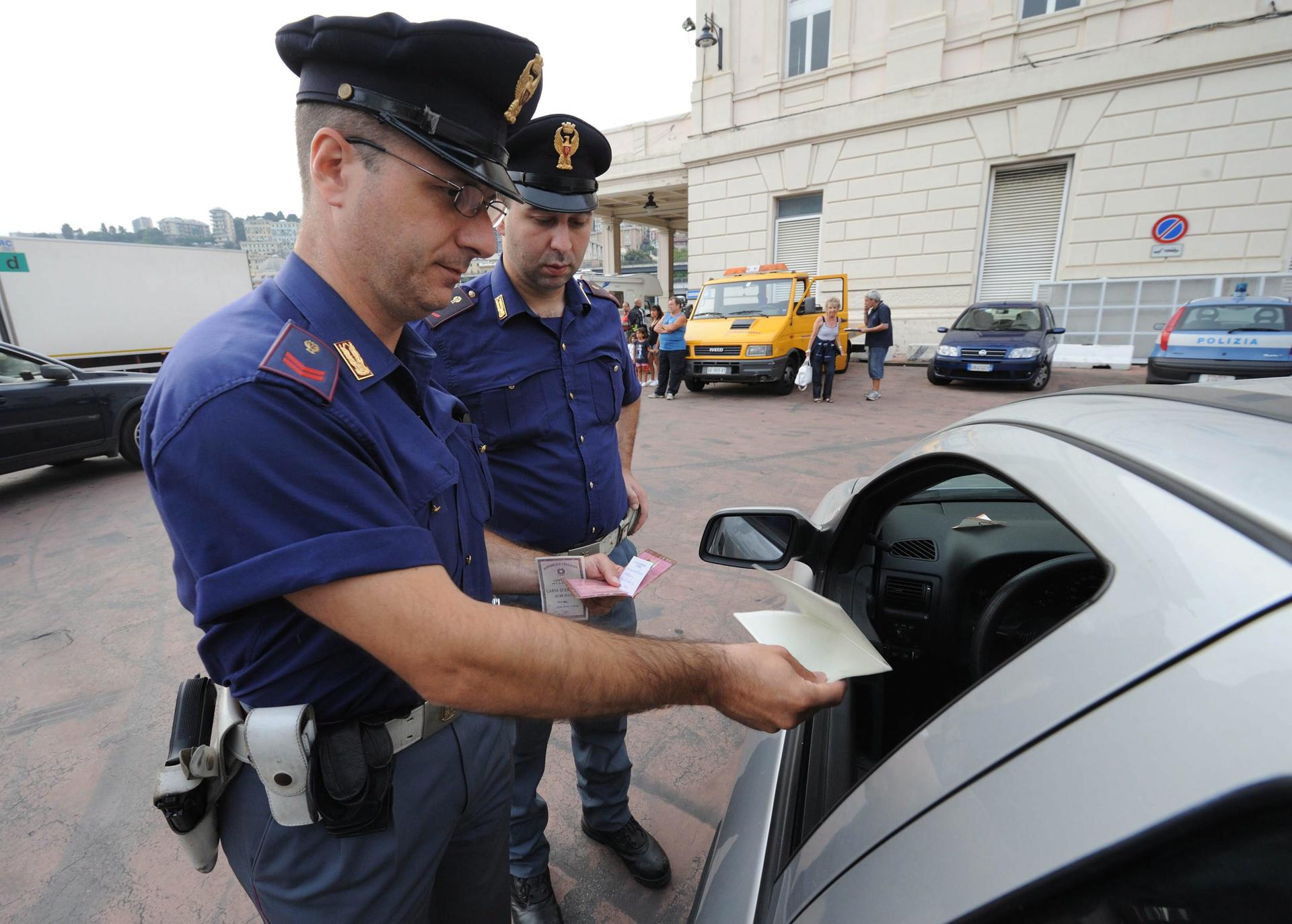 FOTO ARCHIVO. Un policía italiano revisa los documentos de un conductor en Génova, Italia, país en el que se implementó una suspensión temporal del Acuerdo Schengen, debido a la cumbre del G8 que se llevará a cabo en L'Aquila el próximo 8 de julio. EFE/LUCA ZENNARO