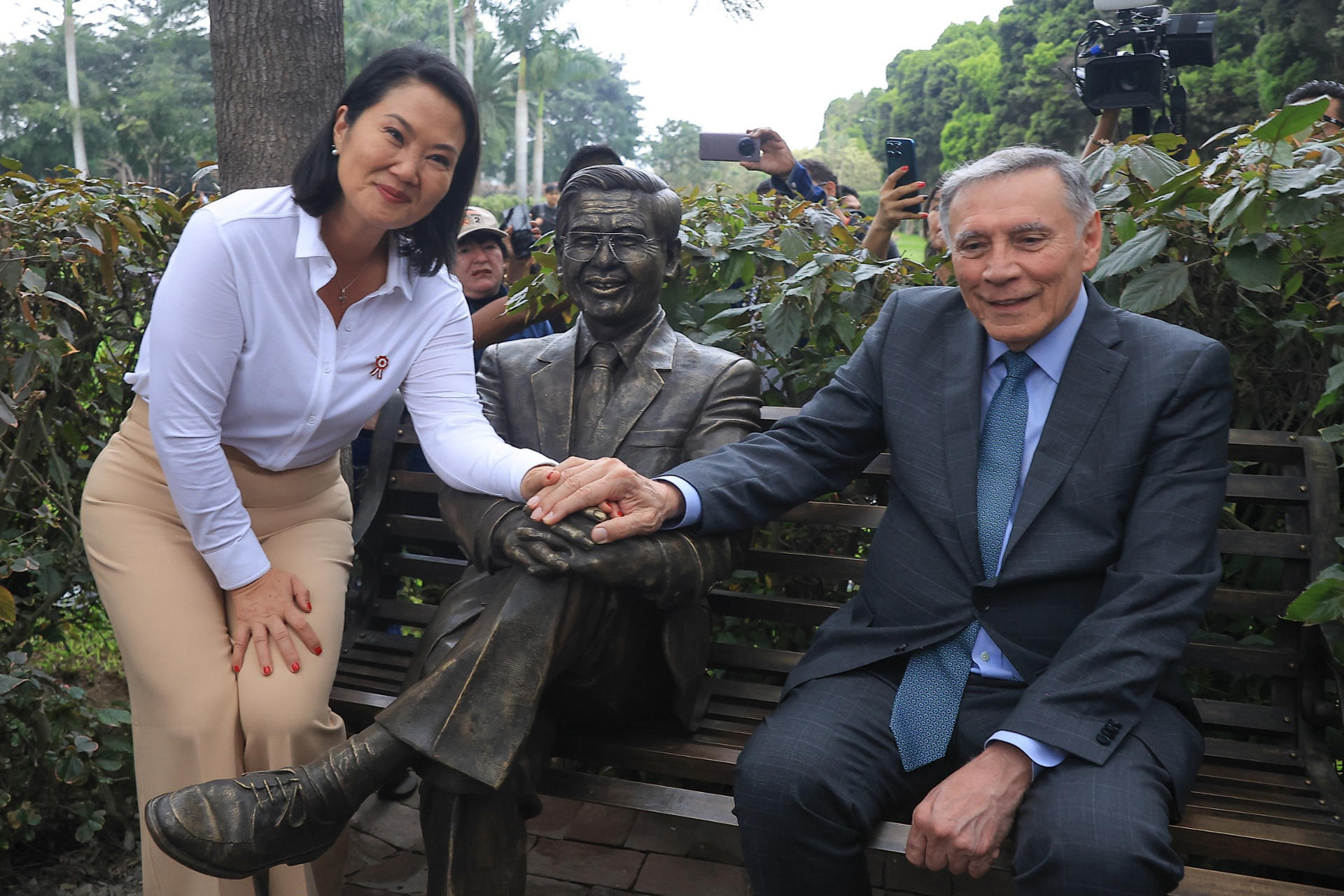 Fotografía cedida por la Presidencia de Perú que muestra a su mandataria, Keiko Fujimori (i), junto al expresidente de Ecuador Jamil Mahuad (d), posando con una estatua del expresidente peruano Alberto Fujimori, padre de la actual mandataria, en el cementerio Campo Fe, de Huachipa, en el este de Lima (Perú). EFE/ Presidencia de Perú