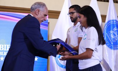 Fotografía cedida por Casa Presidencial de Honduras que muestra al presidente de Honduras, Nasry Asfura (i), entregando una bandera a deportistas que integran la delegación que representará al país en los XXV Juegos Centroamericanos y del Caribe este miércoles, en Tegucigalpa (Honduras). EFE/ Casa Presidencial de Honduras