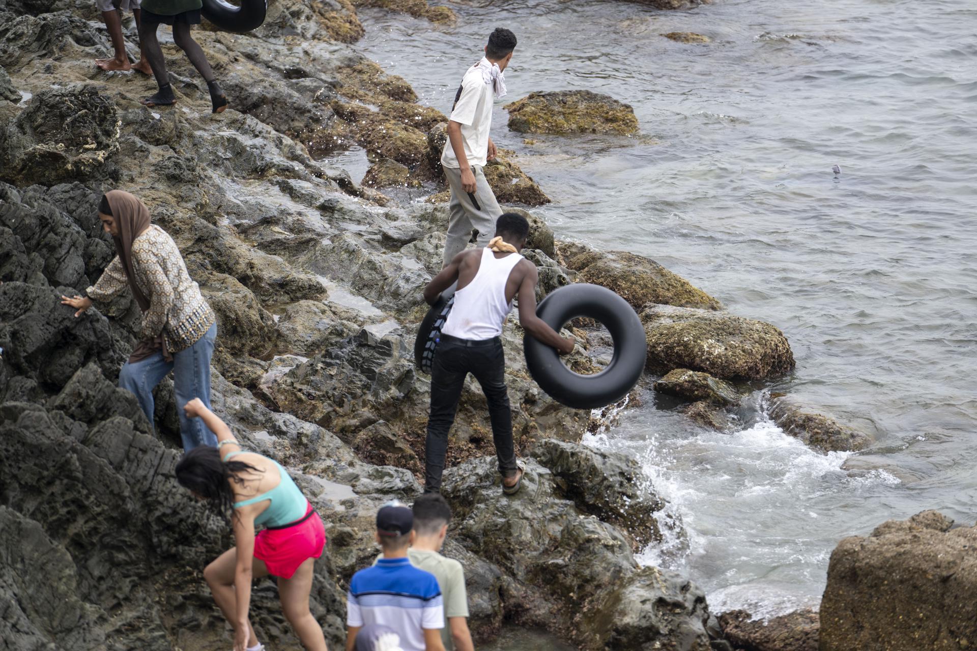 Jóvenes que regresaron de España se reúnen en el cruce fronterizo de Bab Sebta, cerca de Fnideq, Marruecos, el 31 de julio de 2026. Los disturbios estallaron cuando miles de personas se congregaron cerca de la frontera, algunas intentaron cruzar a Ceuta y se enfrentaron a las fuerzas de seguridad marroquíes. (Marruecos, España) EFE/EPA/JALAL MORCHIDI