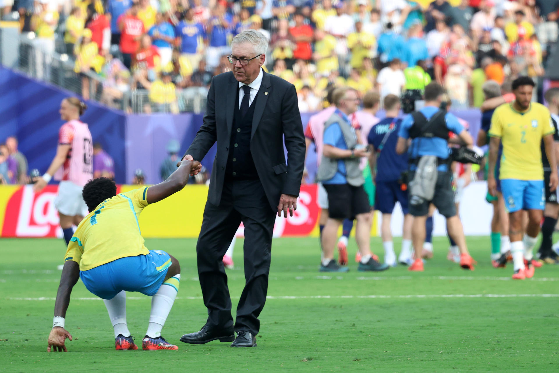 El seleccionador de Brasil Carlo Ancelotti (d) ayuda a ponerse de pie a Vinícius Júnior este domingo, al final de un partido por los octavos de final del Mundial de la FIFA 2026 entre Brasil y Noruega en el estadio MetLife en Nueva Jersey (Estados Unidos). EFE/ Octavio Guzman