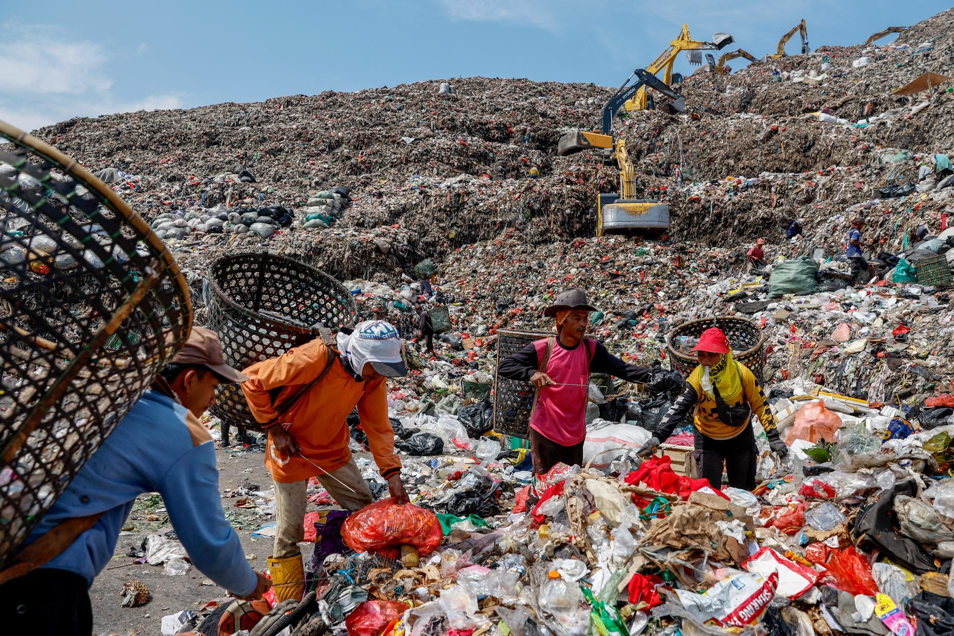 BEKASI (Indonesia), 27/07/2026.- Los recolectores de residuos recogen materiales reciclables mientras las excavadoras gestionan la basura en el vertedero de Bantargebang en Bekasi, Java Occidental, Indonesia, el 27 de julio de 2026. La administración provincial de Yakarta ha comenzado a implementar un sistema de vertedero controlado en Bantar Gebang como parte de su esfuerzo de transformación de la gestión de residuos, con el objetivo de erradicar la práctica de vertidos a cielo abierto en 2029. 
EFE/EPA/MAST IRHAM