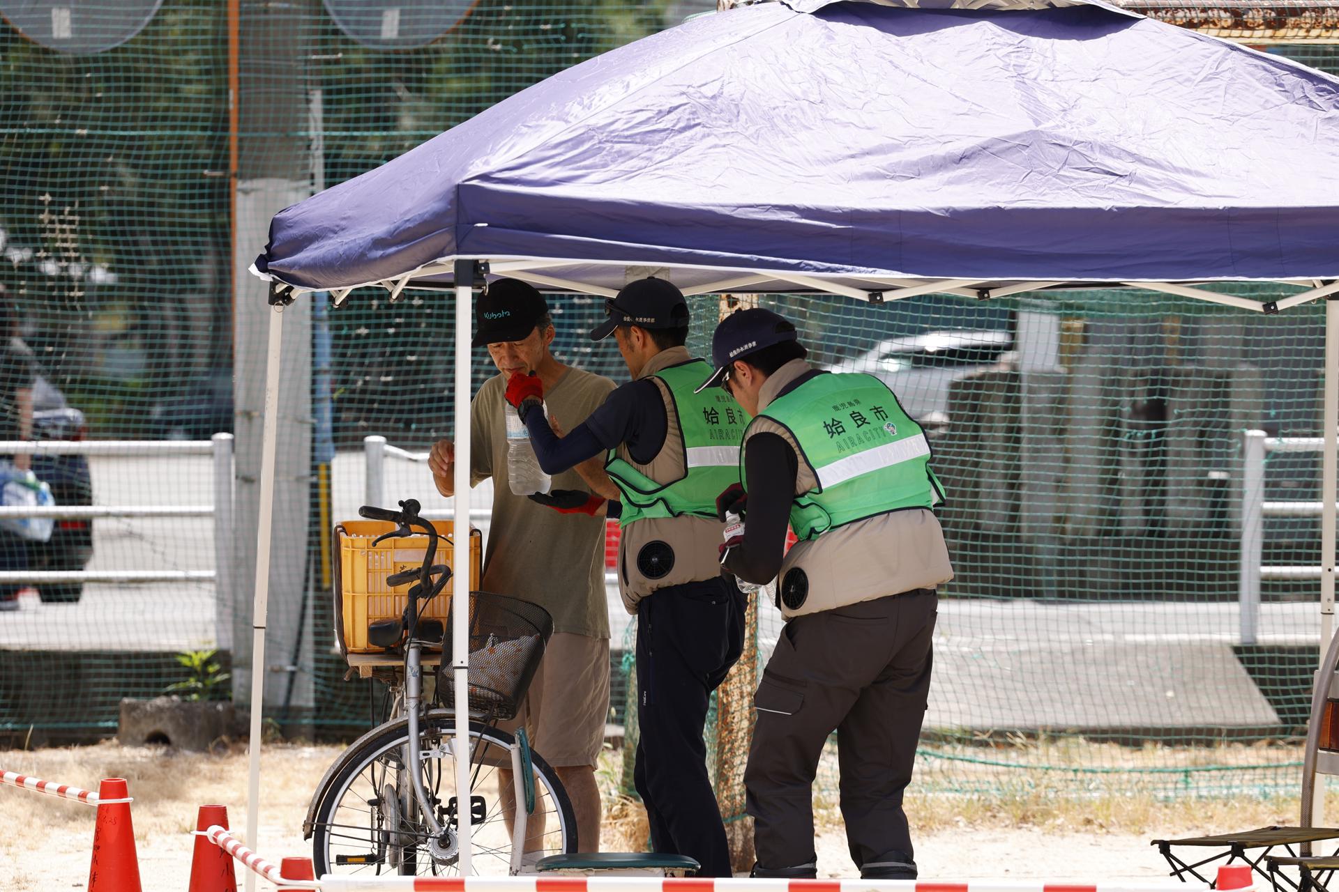 YATSUHIRO (Japan), 31/07/2026.- Personal de rescate entrega agua a un afectado de los terremotos en Kumamoto, Japón. EFE/EPA/RODRIGO REYES MARIN