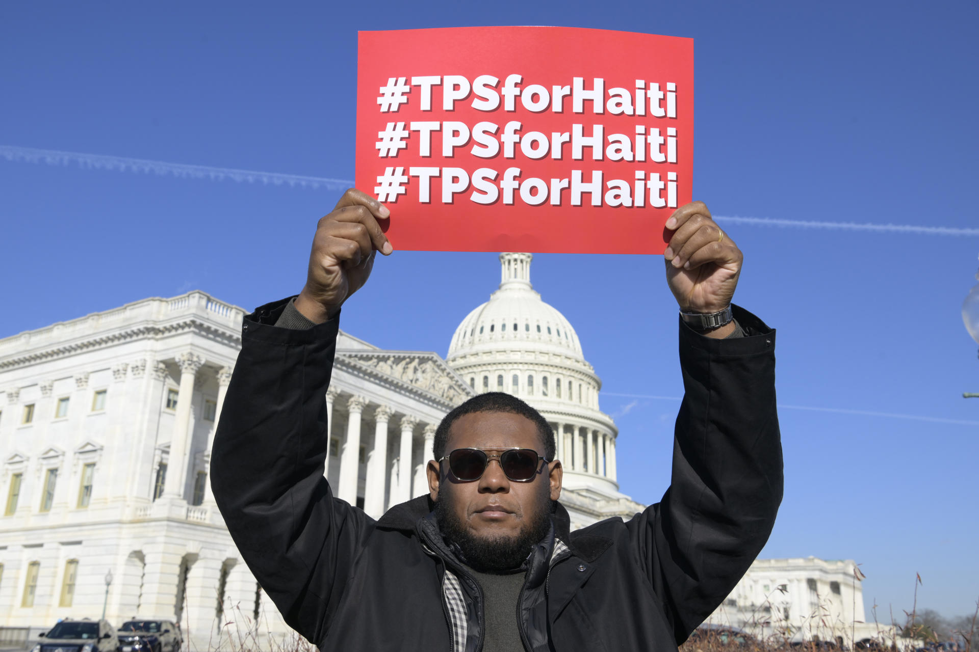 Fotografía de archivo que muestra a un activista sosteniendo un letrero que pide Estatus de Protección Temporal (TPS) para Haití en el triángulo del Congreso en Washington (Estados Unidos). EFE/Lenin Nolly