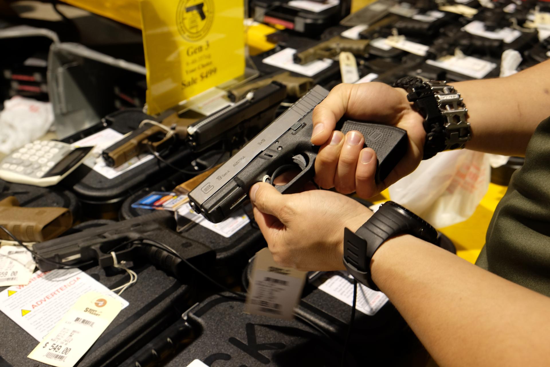Fotografía de archivo en la que se captaron las manos de un hombre al empuñar un arma Glock 19, en Miami (FL, EE.UU.). EFE/Gaston de Cárdenas
