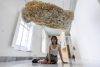 La artista ecuatoriana Nebraska Flores posa junto a su obra 'Escritura fósil', en la muestra titulada 'Los de aquí', en la que participan nueve artistas de Ecuador que hacen dialogar el arte contemporáneo con los movimientos migratorios, en Cartagena (España), con motivo del Festival Mar de Músicas, este año dedicado a Ecuador. EFE/Marcial Guillén