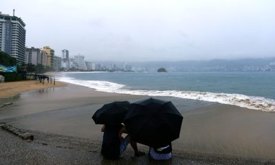 Personas se protegen de la lluvia en Acapulco (México). Fotografía de archivo. EFE/David Guzmán