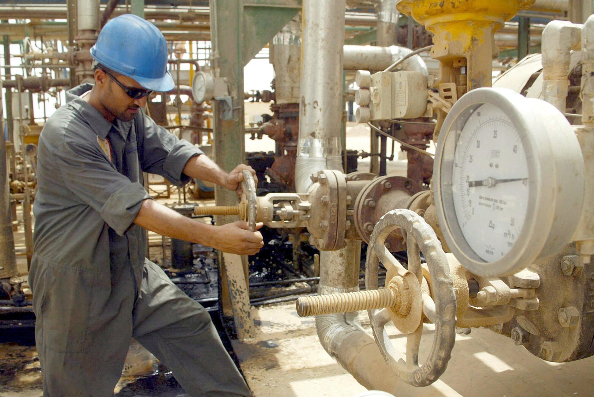 Un operario abre una válvula en una refinería de Najaf, en Irak, en una foto de archivo. EFE/Hussein Al-Mousawi