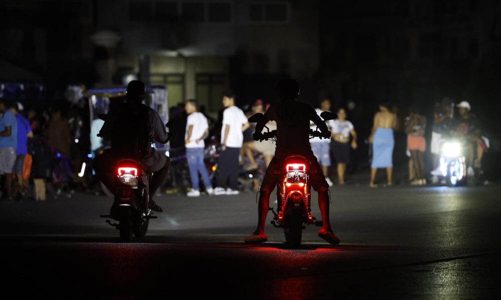 Personas en motocicleta transitan por un calle durante un apagón este sábado, en La Habana (Cuba). EFE/ Ernesto Mastrascusa