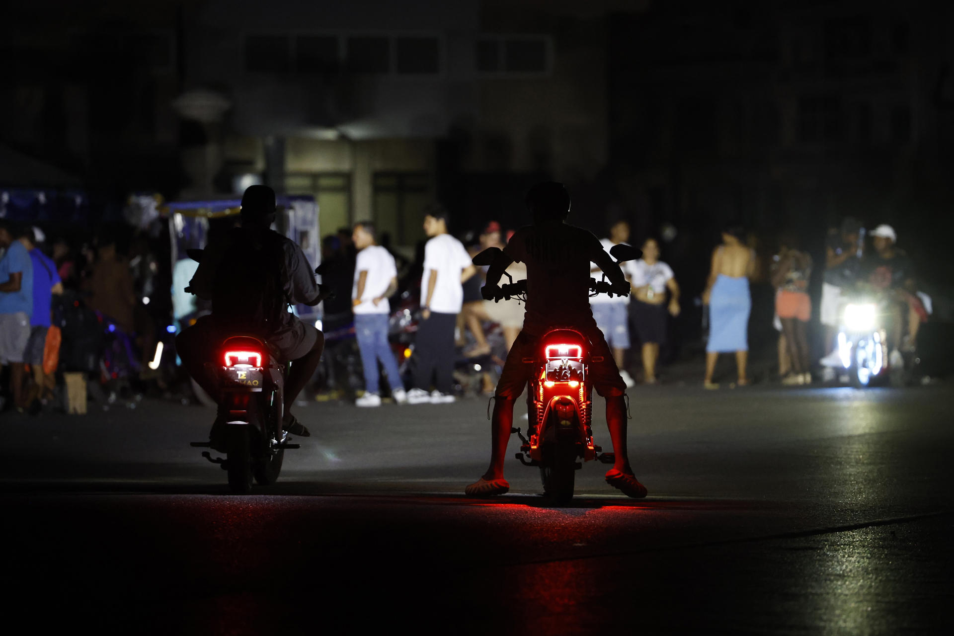 Personas en motocicleta transitan por un calle durante un apagón este sábado, en La Habana (Cuba). EFE/ Ernesto Mastrascusa