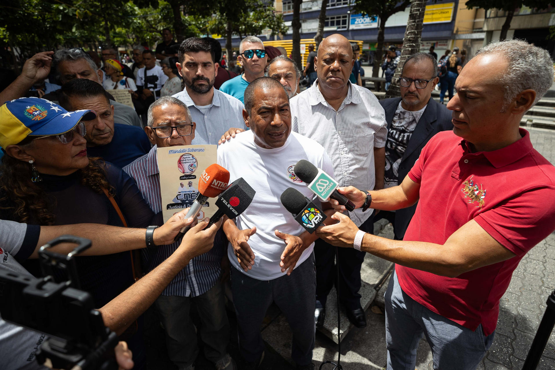 El integrante de la Coalición Sindical Nacional, Carlos Salazar, habla con periodistas durante un acto donde se exige que se celebren elecciones presidenciales este año en el país suramericano, al cumplirse siete meses de la captura de Nicolás Maduro por parte de tropas estadounidenses, este lunes, en Caracas (Venezuela). EFE/ Ronald Peña R