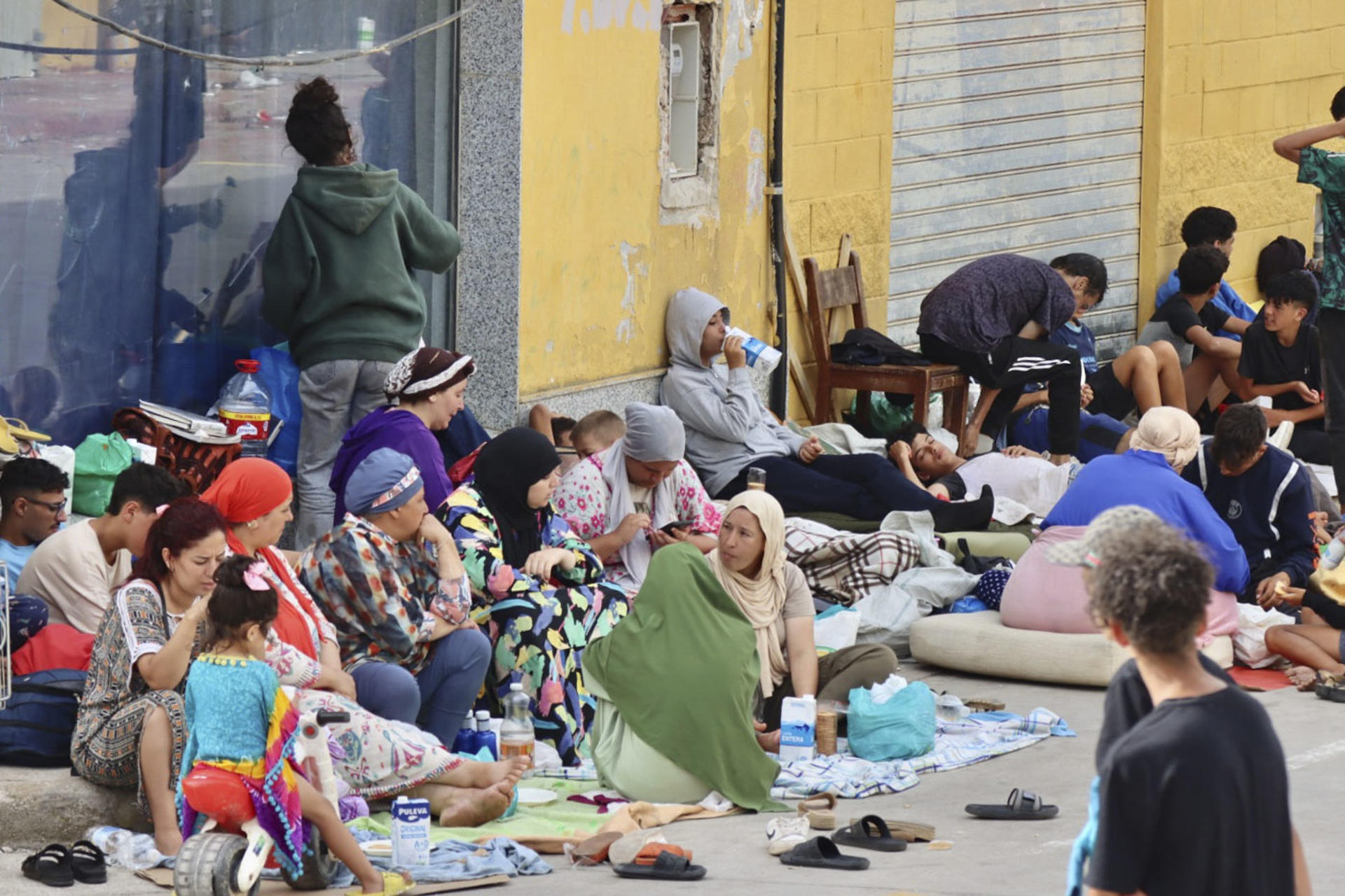 Cientos de inmigrantes marroquíes descansan en las calles de Ceuta, este lunes. La vigilancia en el entorno de la frontera del Tarajal, tanto por vía marítima como terrestre, así como los nuevos medios de contención en la zona con la instalación de una barrera en el mar han reducido al mínimo las entradas a nado desde Marruecos. EFE/Reduan